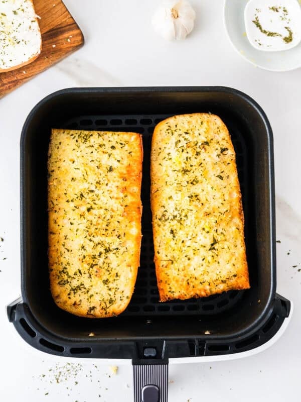 Cooked garlic bread in an air fryer basket.