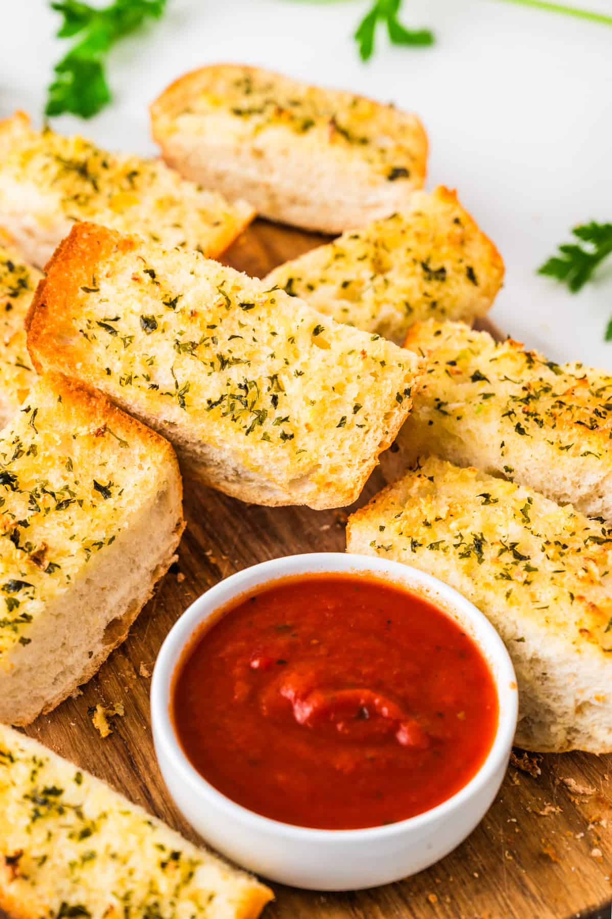 This tasty and easy air fryer garlic bread has crisp edges, a soft buttery center, and bold garlic flavor. A fast, oven-free side dish ready in 5 minutes. Air Fryer Garlic Bread cut into slices and served with a bowl of marinara sauce.