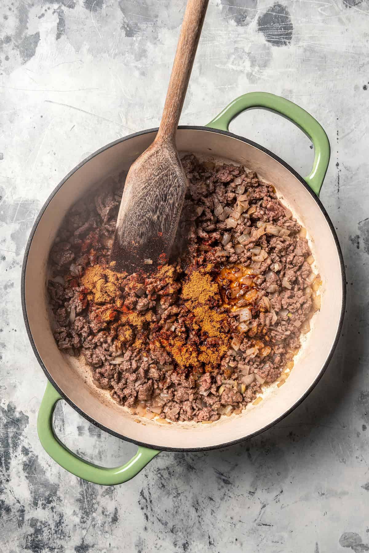 Taco seasoning added to a pot of browned ground beef.