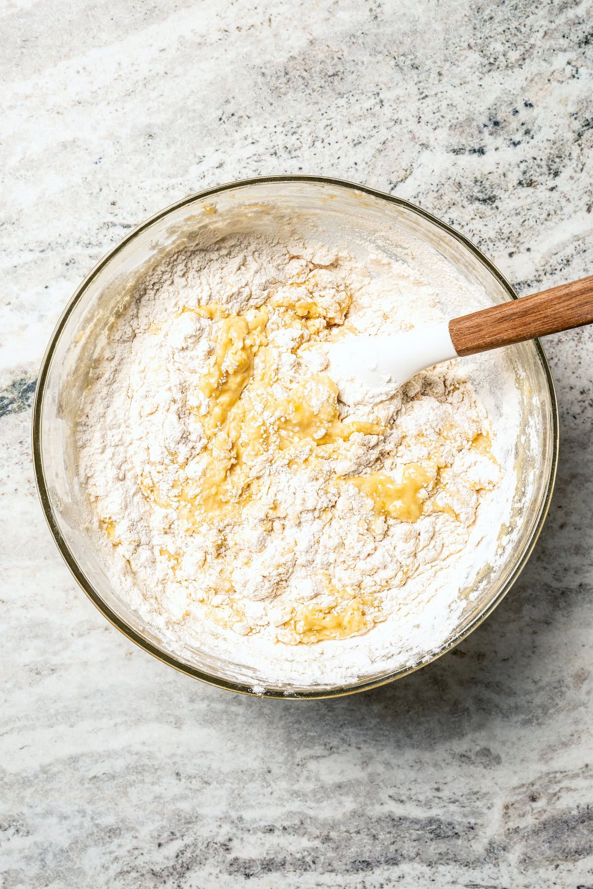 Dry ingredients added to a bowl of wet dough ingredients.