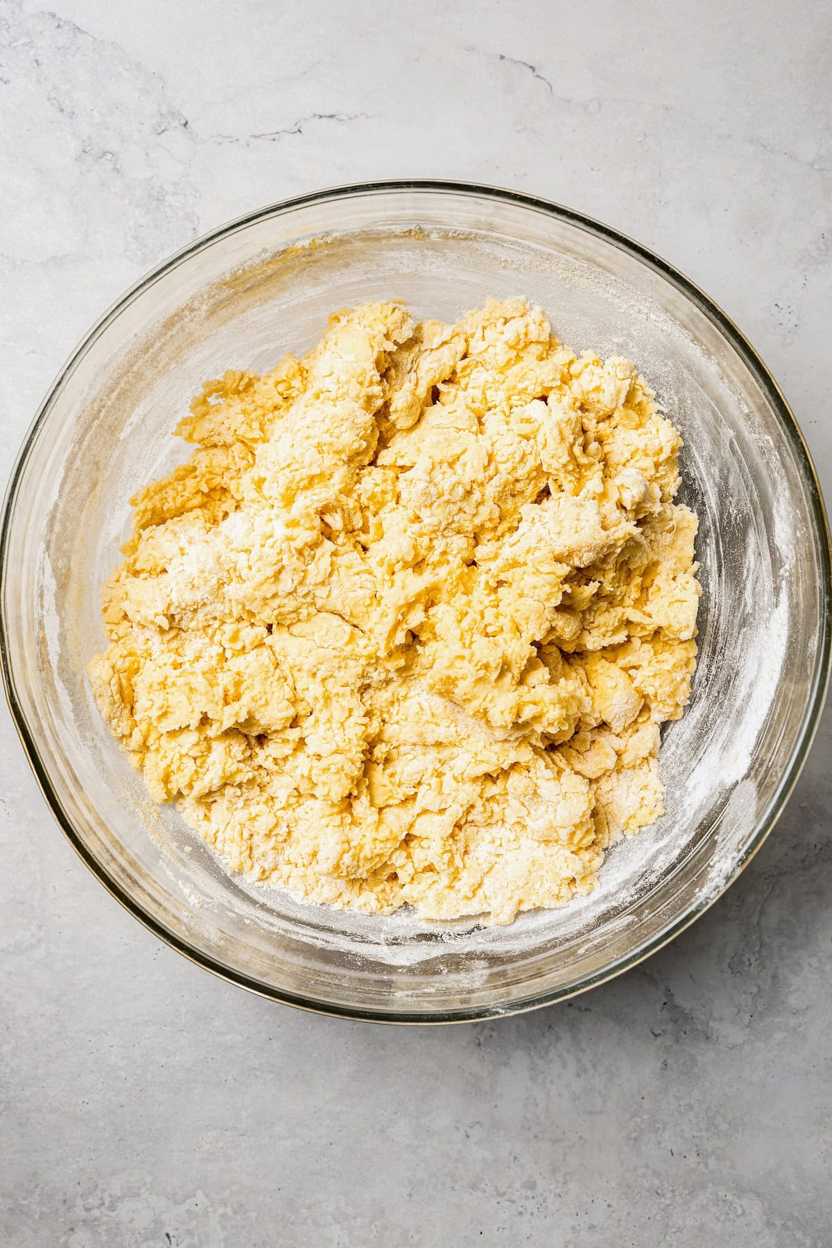 These old-fashioned sour cream donuts are soft and cakey beneath a golden crust coated in creamy vanilla glaze. No yeast or rising time! Donut dough in a glass bowl.