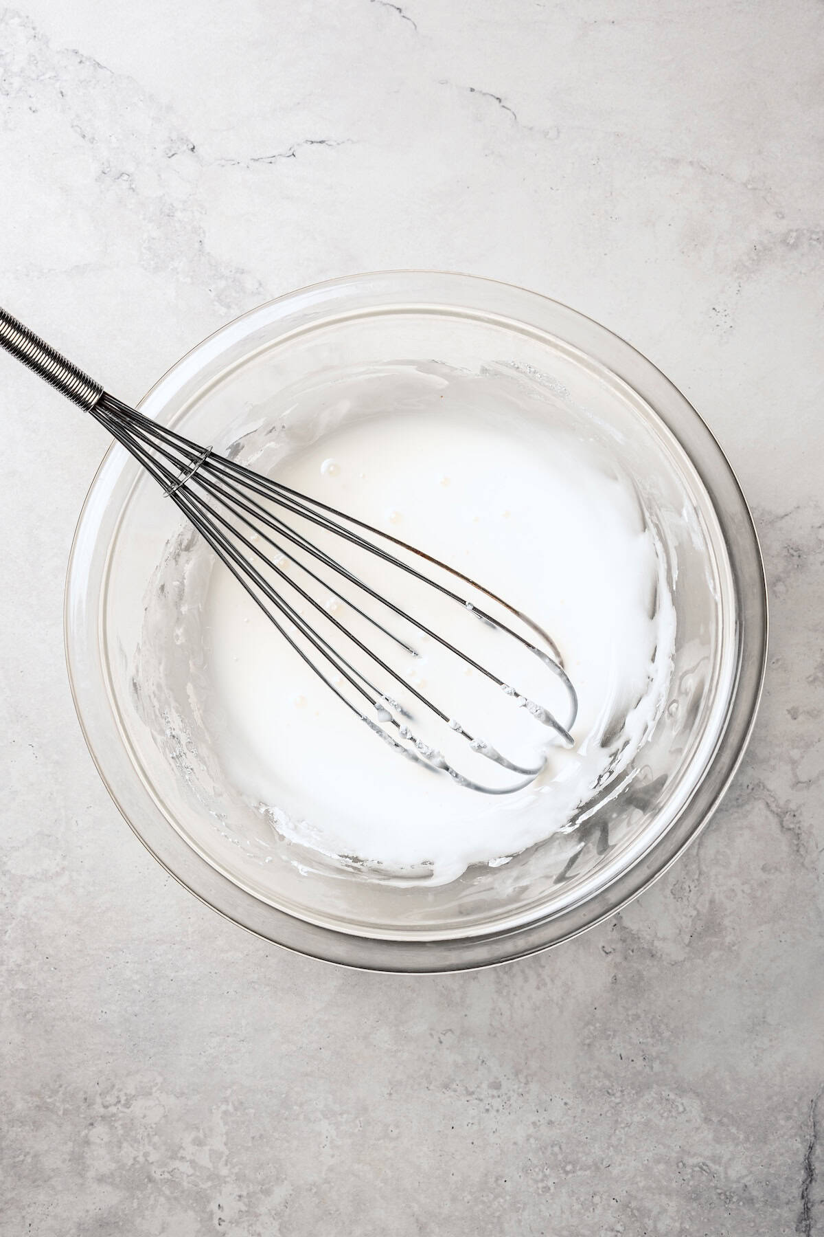 These old-fashioned sour cream donuts are soft and cakey beneath a golden crust coated in creamy vanilla glaze. No yeast or rising time! Glaze in a bowl with a whisk.