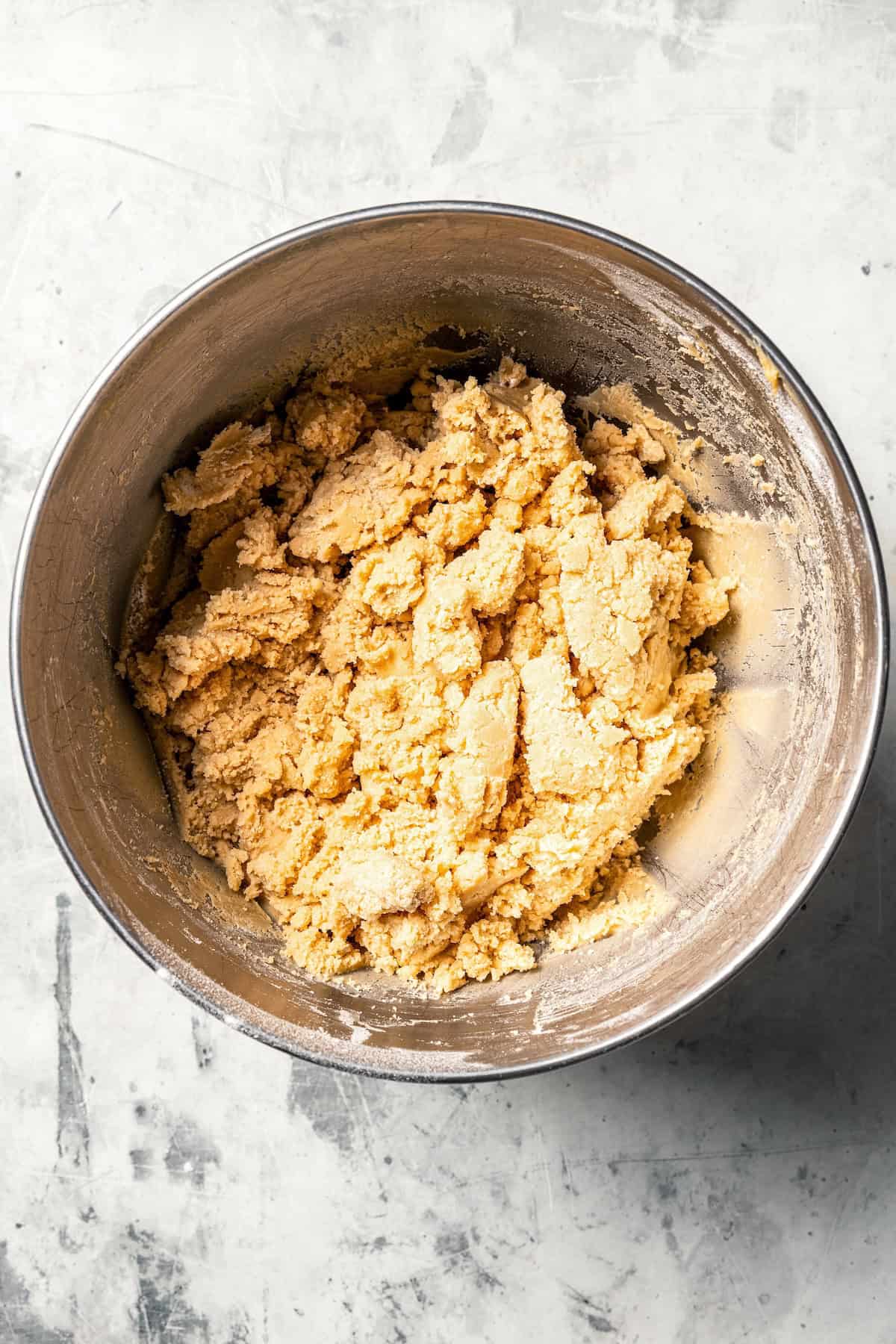 Mixing cookie butter into the dough makes the best sugar cookie bars ever! These bars are soft and chewy, topped with creamy frosting. Sugar cookie dough in a mixing bowl.