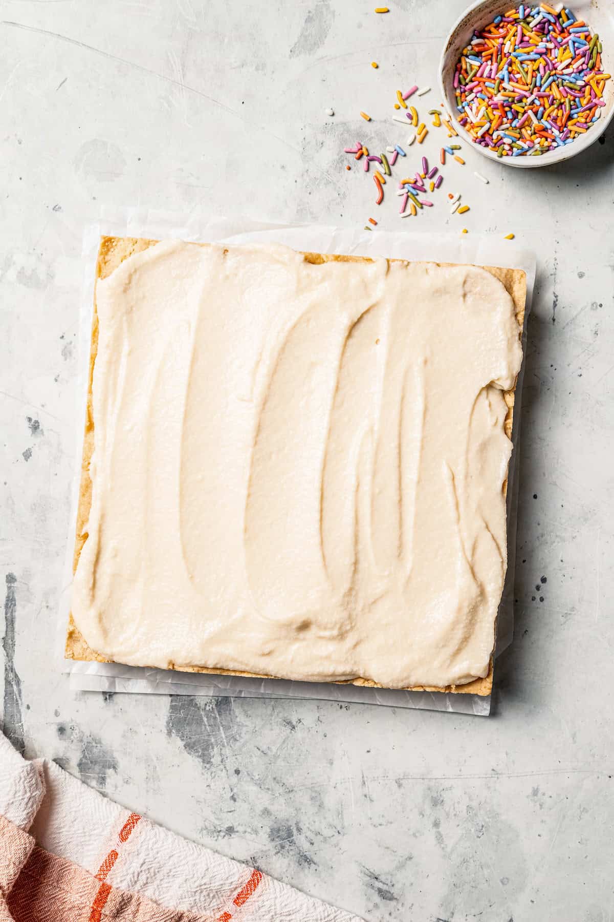 Mixing cookie butter into the dough makes the best sugar cookie bars ever! These bars are soft and chewy, topped with creamy frosting. A sugar cookie bar slab topped with frosting.