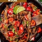 Thinly sliced beef and chopped vegetables in a skillet.