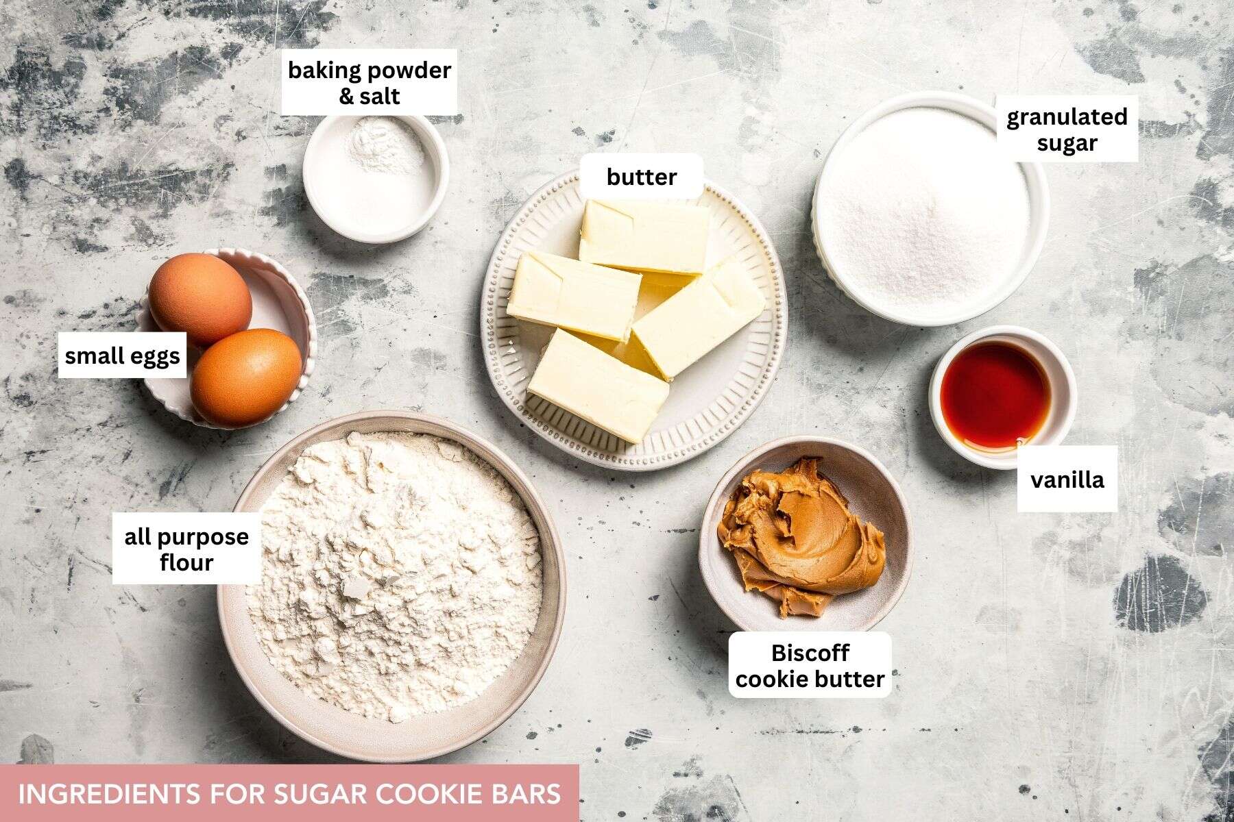 Mixing cookie butter into the dough makes the best sugar cookie bars ever! These bars are soft and chewy, topped with creamy frosting. Sugar cookie bars ingredients with text labels overlaying each ingredient.