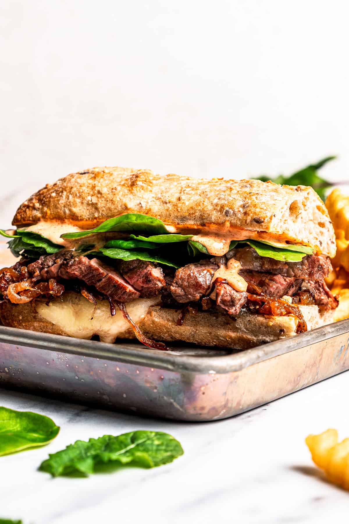 A steak sandwich on a tray.