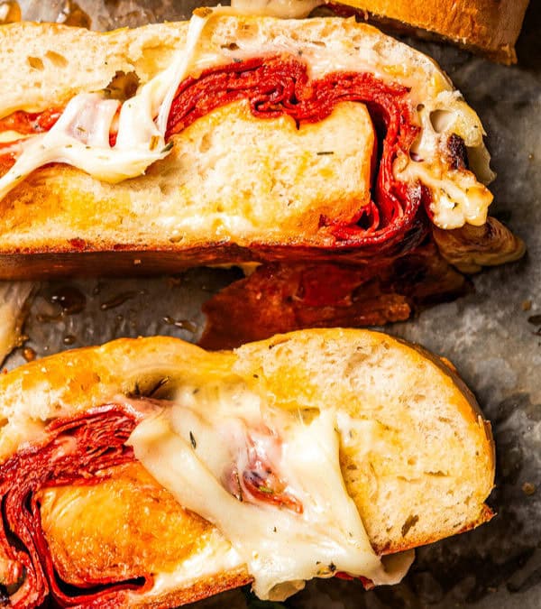 Stromboli cut into slices on a parchment-lined baking sheet.
