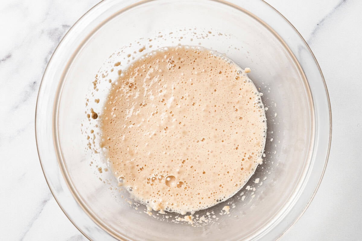 Yeast activated in a bowl of warm water and sugar.