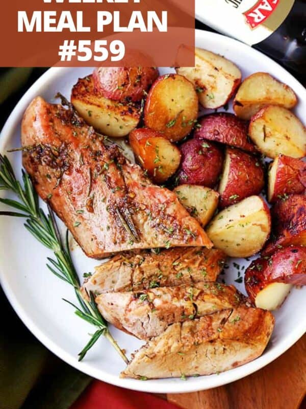 Sliced pork tenderloin with potatoes served on a plate.