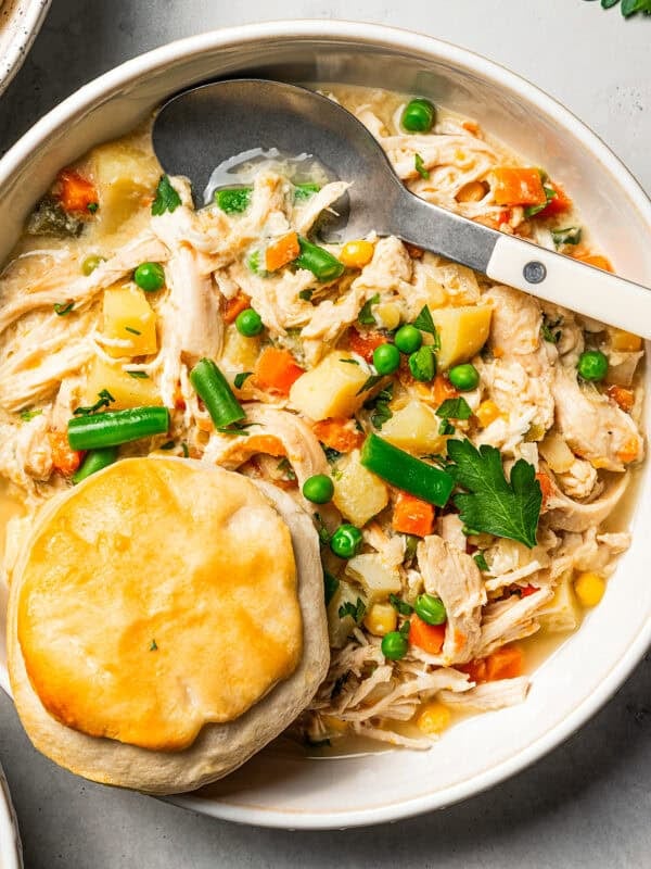 Slow cooker chicken pot pie in a bowl topped with a golden biscuit.