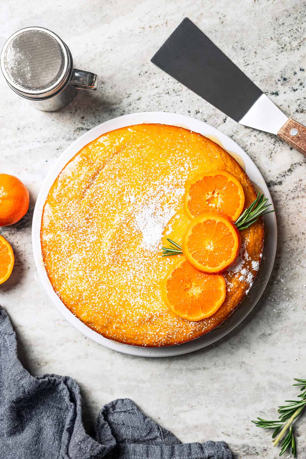 This orange cake recipe uses whole oranges, peels and all! It's moist and full of sweet citrus flavor, drenched in orange glaze. An orange cake dusted with powdered sugar and topped with fresh orange slices.