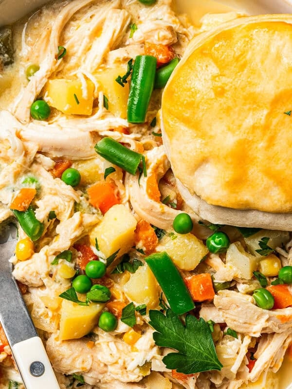 Slow cooker chicken pot pie in a bowl topped with a golden biscuit.