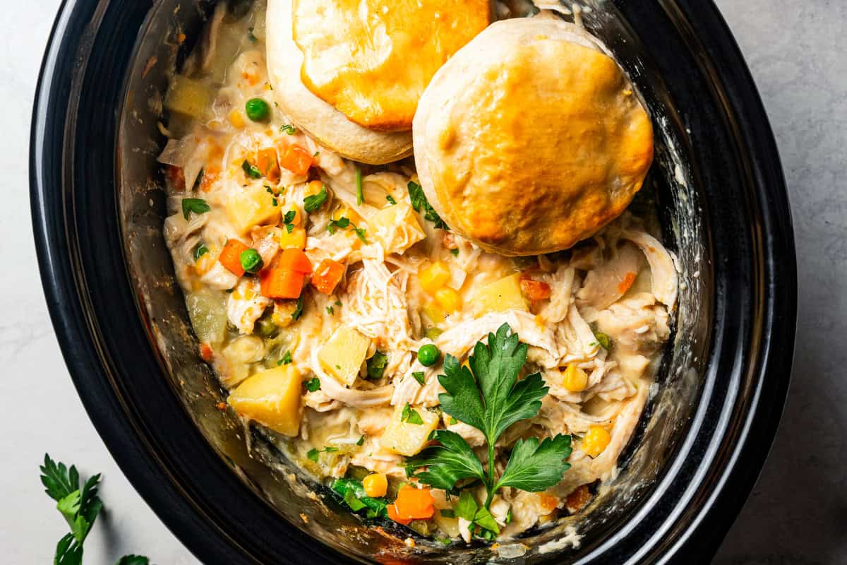 Overhead view of two biscuits on top of chicken pot pie in the slow cooker.