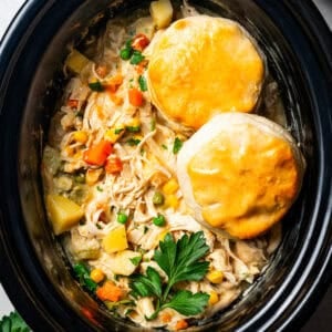 two biscuits on top of chicken pot pie in the slow cooker.