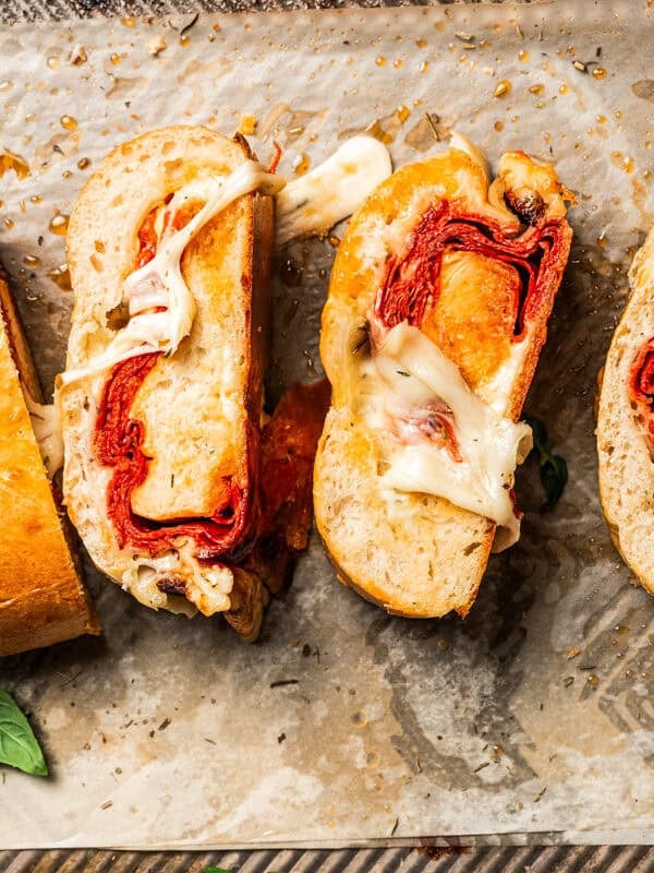 Stromboli cut into slices on a parchment-lined baking sheet.
