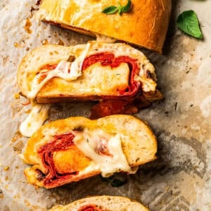 Stromboli cut into slices on a parchment-lined baking sheet.