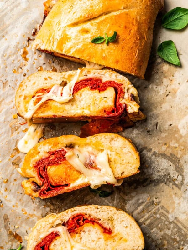 Stromboli cut into slices on a parchment-lined baking sheet.