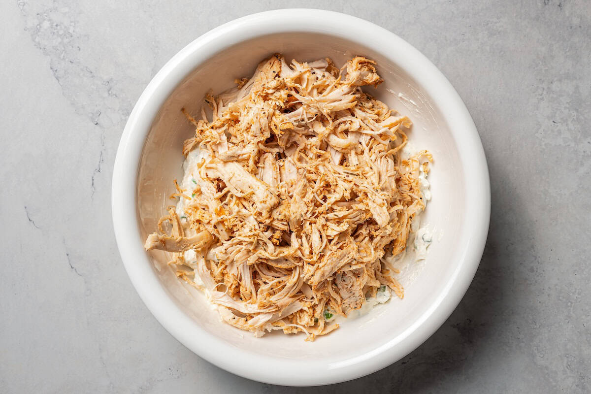 Chicken added to the cottage cheese mixture in a bowl.