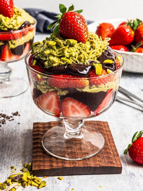 Dubai chocolate strawberries in a glass dessert cup with a second cup in the background.
