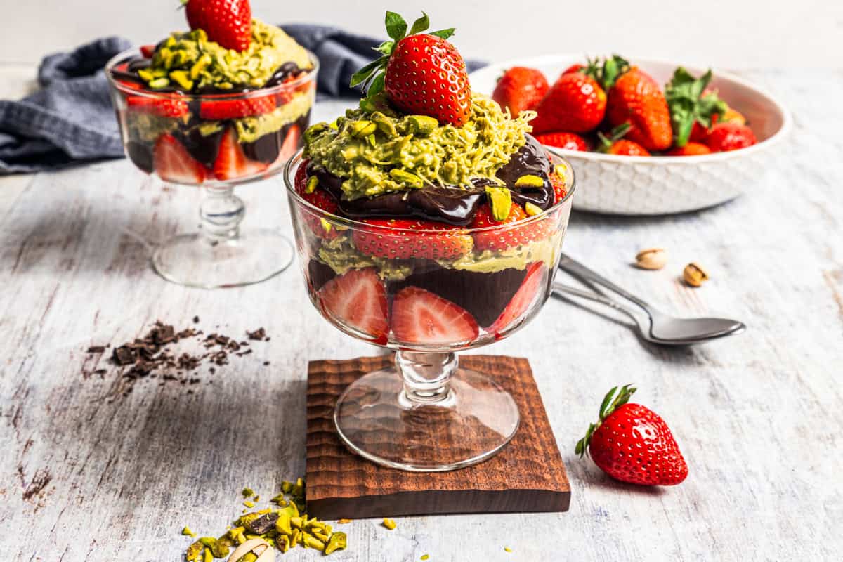 Dubai chocolate strawberries in a glass dessert cup with a second cup in the background.