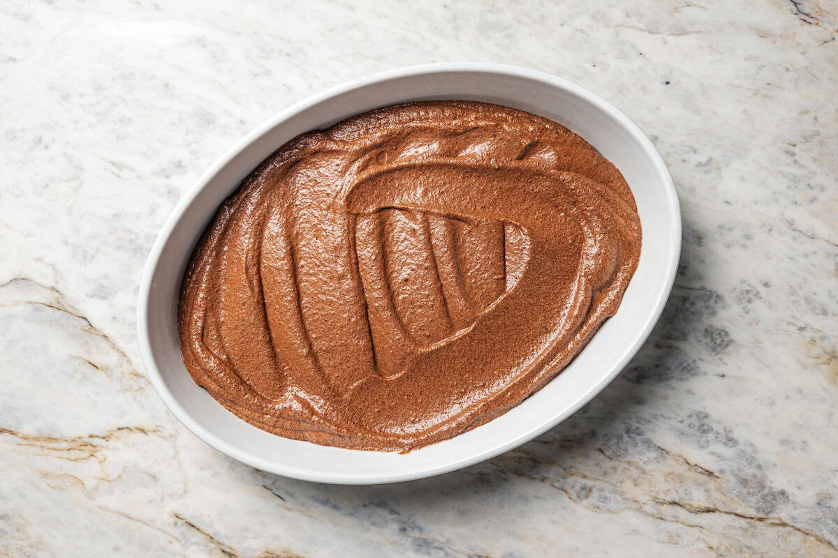 Fudge cake batter spread into an oval baking dish.