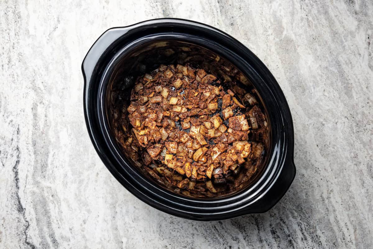 Onion and seasoning mixture added to the slow cooker.