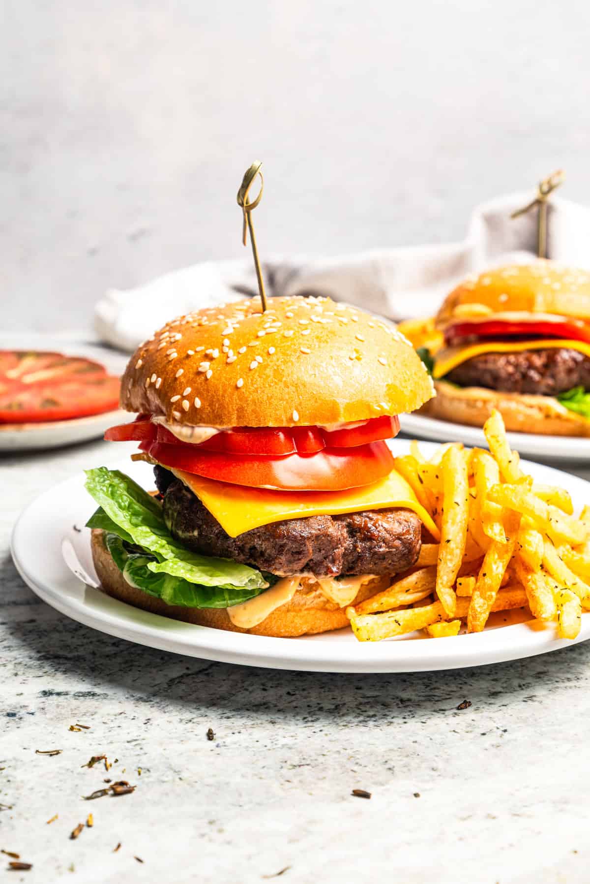 Air fryer hamburgers served on a plate with a side of fries.