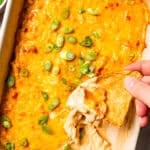 Dipping a tortilla chip in buffalo chicken dip.