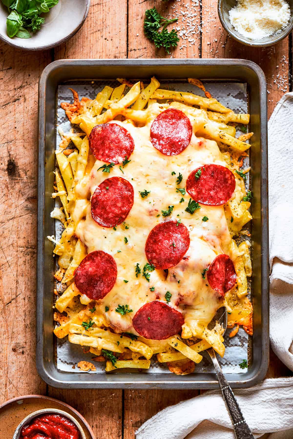 A tray of French fries topped with melted cheese and pepperoni.