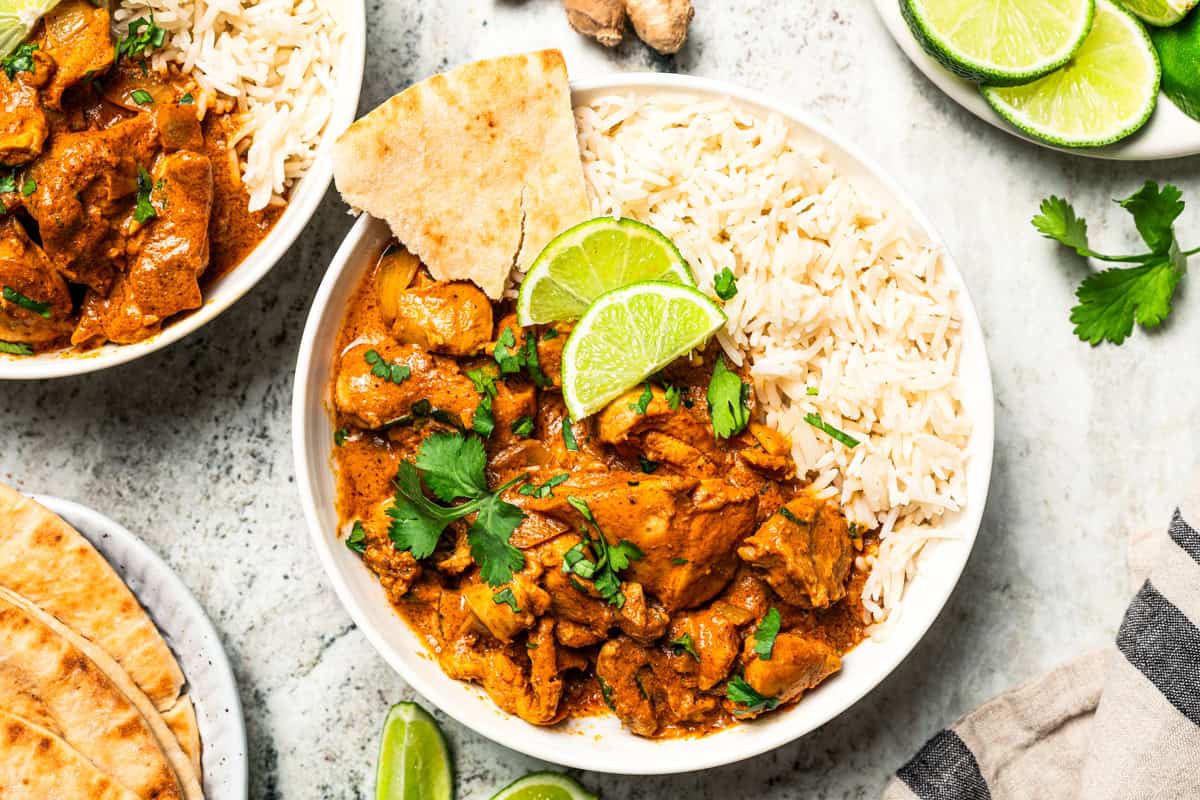 A bowl of Indian butter chicken served over rice.