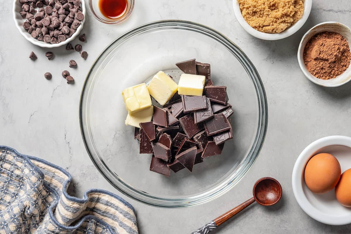 These chewy brownie cookies are the best of a fudgy brownie crossed with a soft-baked chocolate cookie! Made with real melted chocolate. Chopped chocolate and butter combined in a bowl.