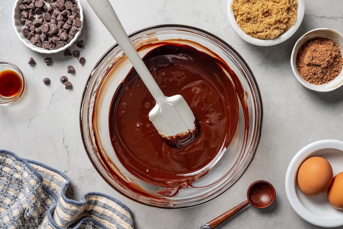 These chewy brownie cookies are the best of a fudgy brownie crossed with a soft-baked chocolate cookie! Made with real melted chocolate. Melted chocolate in a bowl.