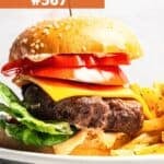 Hamburger in buns piled up with tomato slices and cheese.