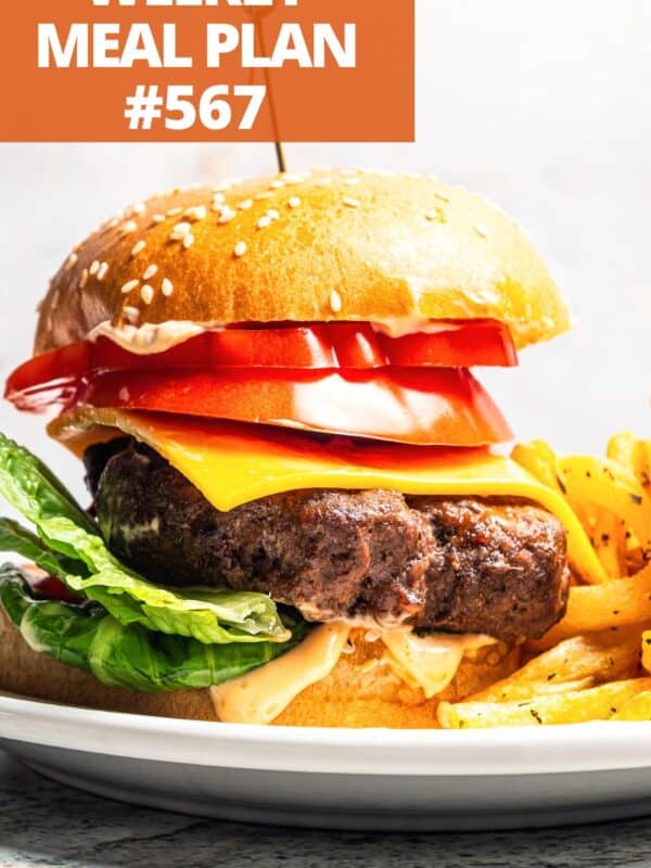 Hamburger in buns piled up with tomato slices and cheese.