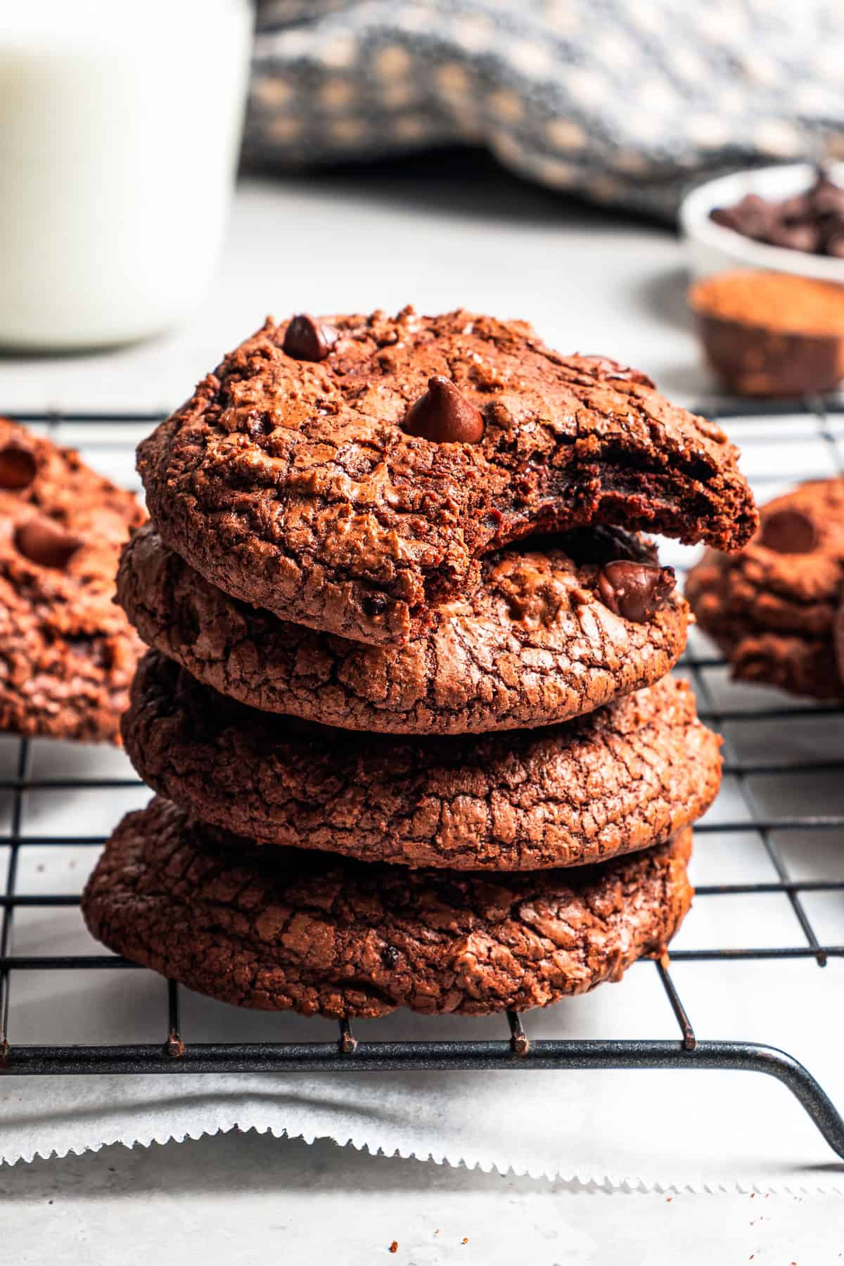 These chewy brownie cookies are the best of a fudgy brownie crossed with a soft-baked chocolate cookie! Made with real melted chocolate. A stack of four brownie cookies, with the top one missing a bite.