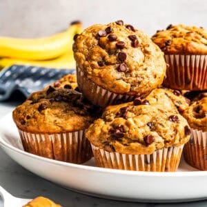 Moist, tender peanut butter banana muffins stacked on a plate.