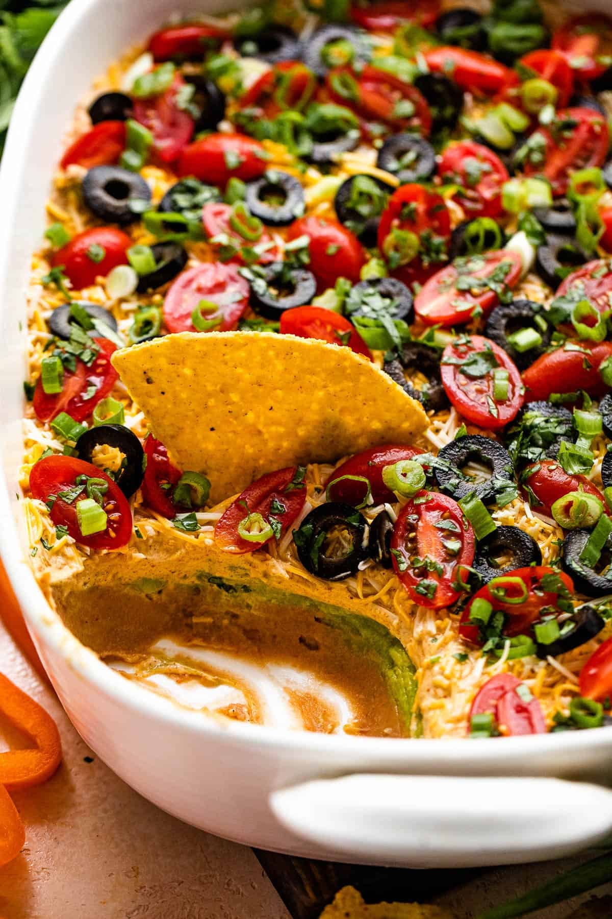 Weekly Meal Plan Seven-layer dip with refried beans, guacamole, sour cream, tomatoes, and more in a dish.