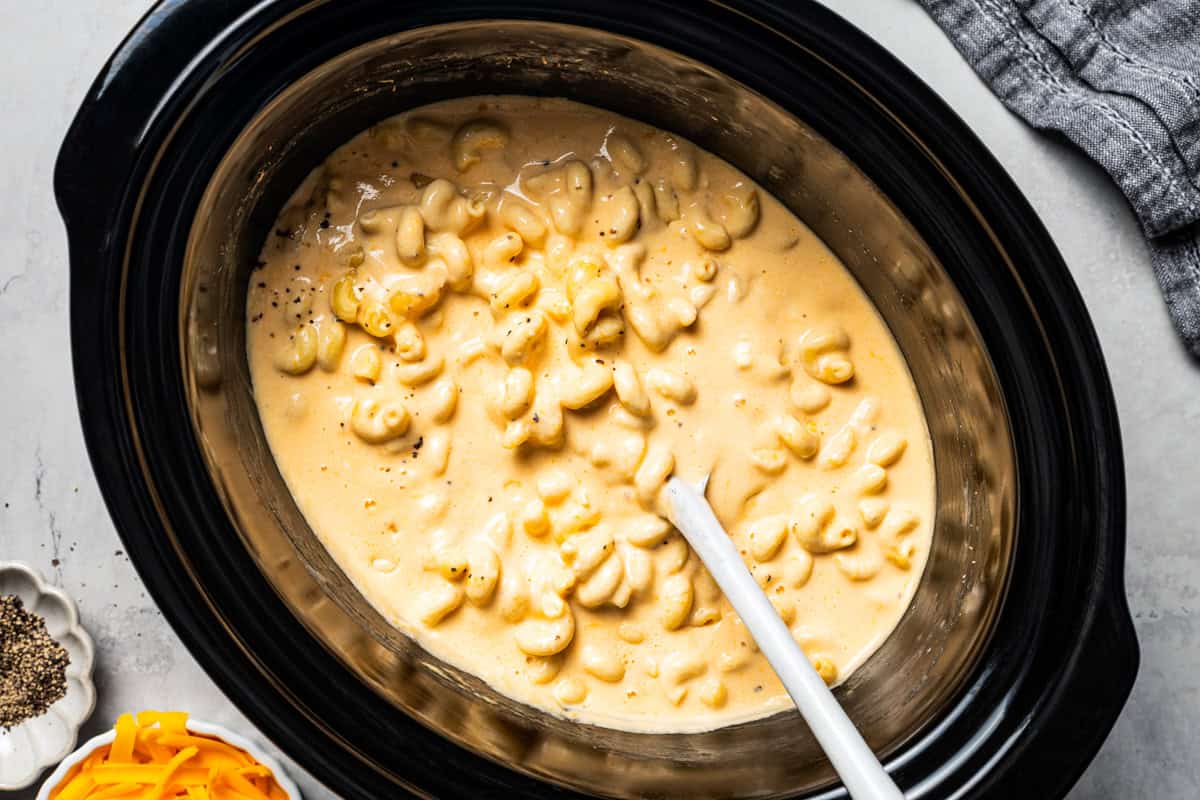 Ultra-creamy slow cooker mac and cheese is a dump-and-go version of my homemade mac and cheese recipe! Perfect for potlucks and holidays. Cheesy crockpot mac and cheese in the slow cooker.