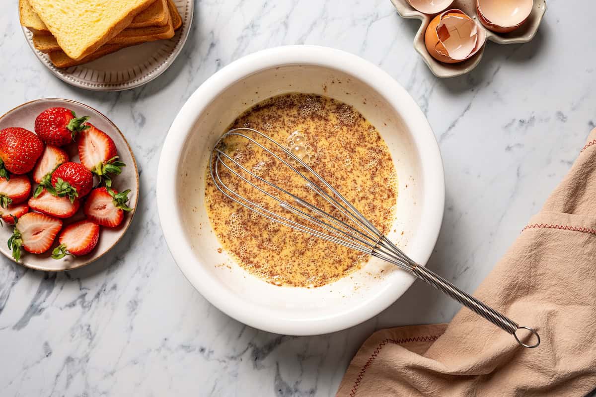 Make this cream cheese stuffed French toast with thick slices of custard-dipped brioche filled with sweet mascarpone and fresh lemon zest. Cinnamon egg custard in a bowl.