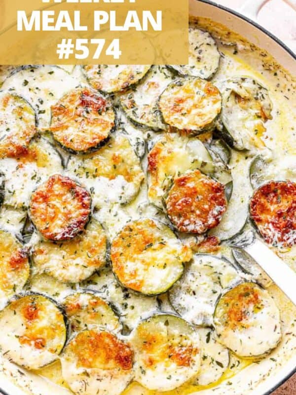 A baking dish of baked zucchini slices in a creamy Parmesan sauce.