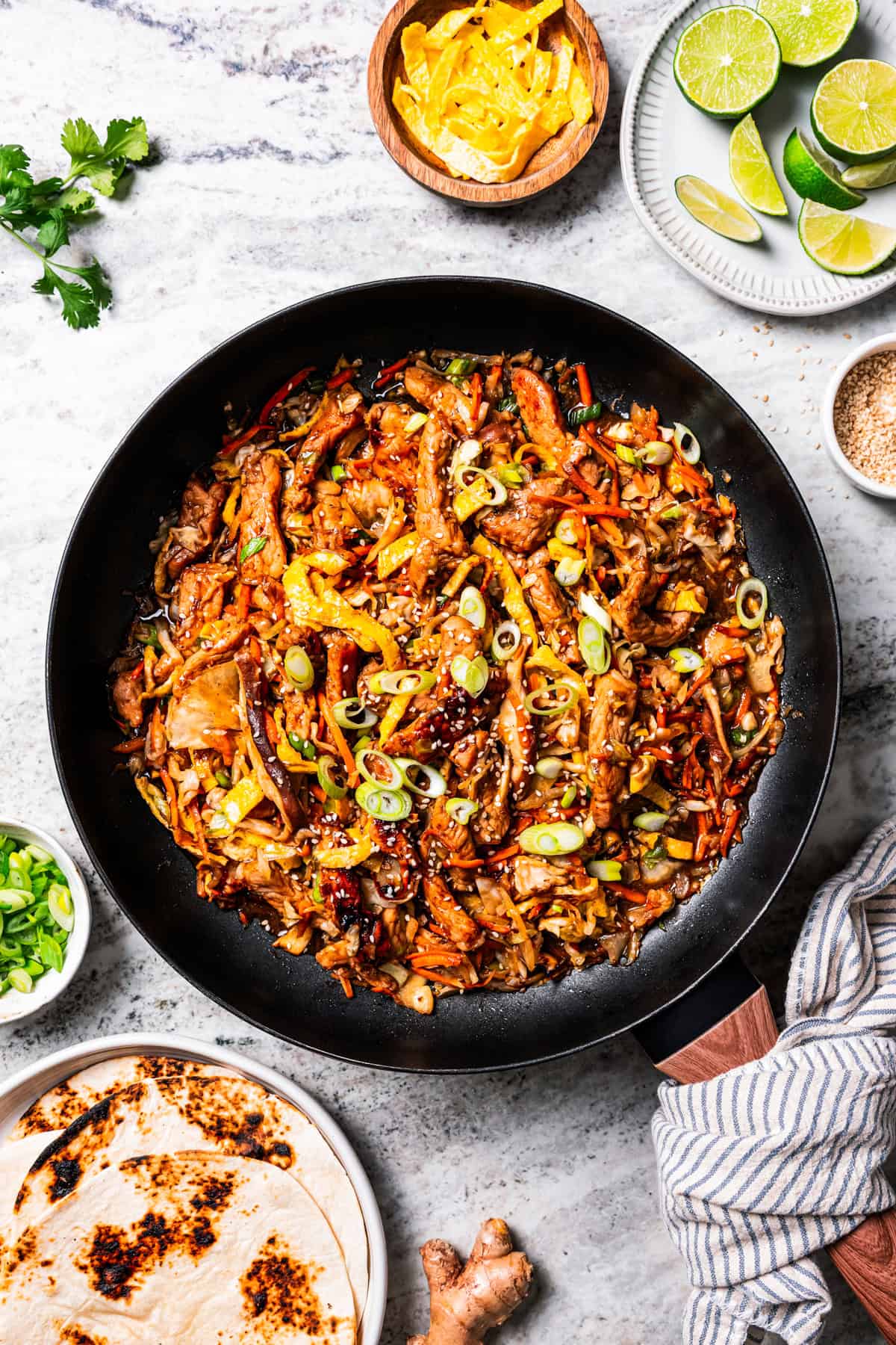 Craving moo shu pork for dinner? This homemade copycat is better than takeout and ready in 25 minutes with pork, veggies, and savory sauce. Chinese moo shu pork stir fry in a large skillet.
