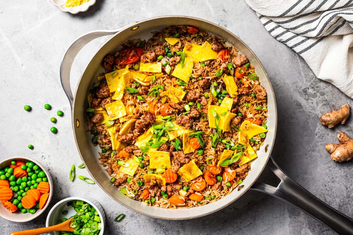Pork fried rice is a quick, one-pan dinner packed with crispy ground pork, cooked eggs, and veggies. It's the best way to use up day-old rice! Homemade pork fried rice in a skillet.
