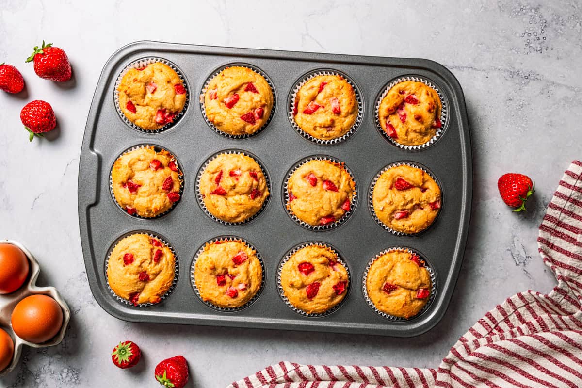 These moist strawberry protein muffins with applesauce, cottage cheese, and protein powder make an easy, light breakfast or meal prep snack! Freshly baked protein muffins in a muffin tin.