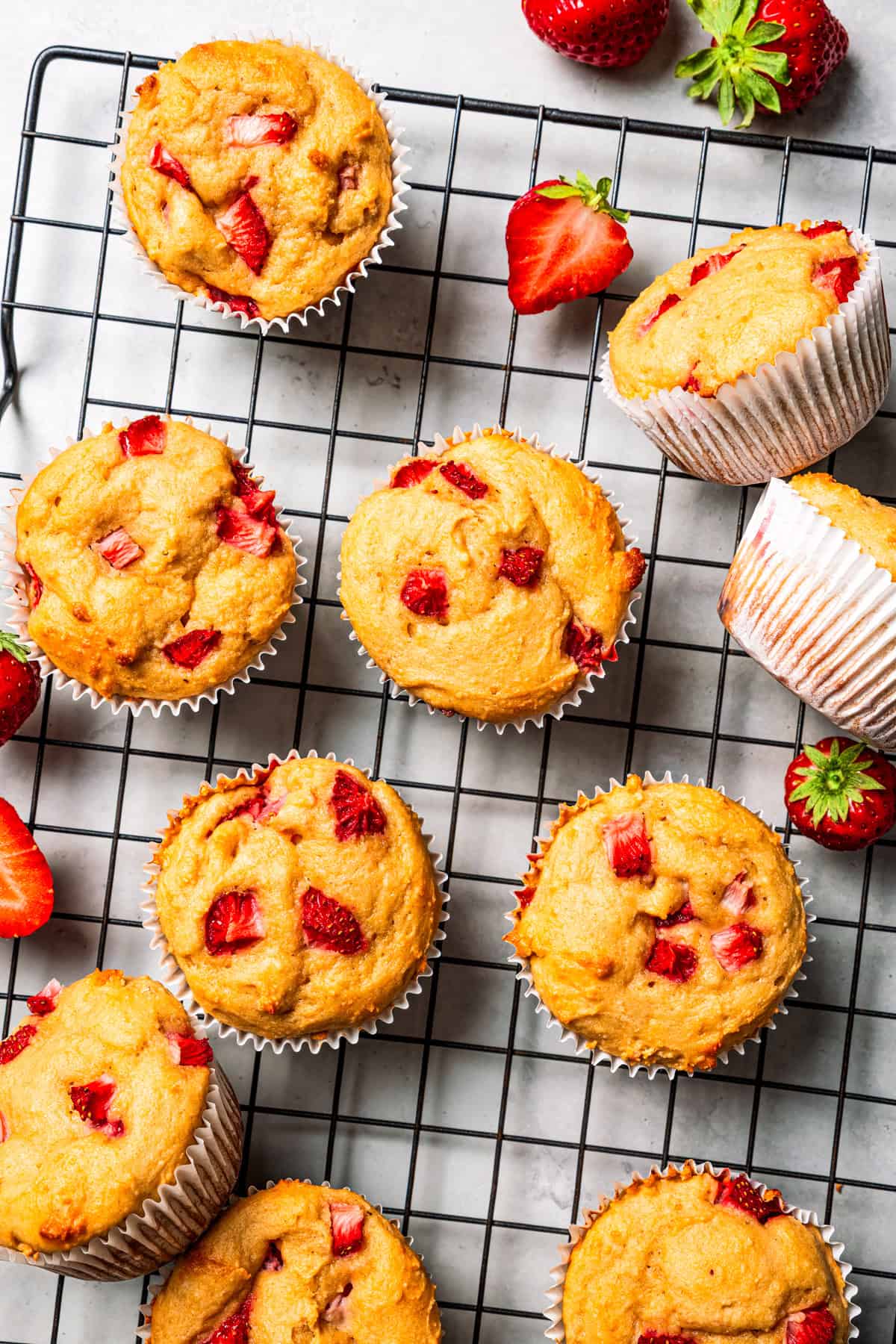 These moist strawberry protein muffins with applesauce, cottage cheese, and protein powder make an easy, light breakfast or meal prep snack! Protein muffins cooling on a wire rack.