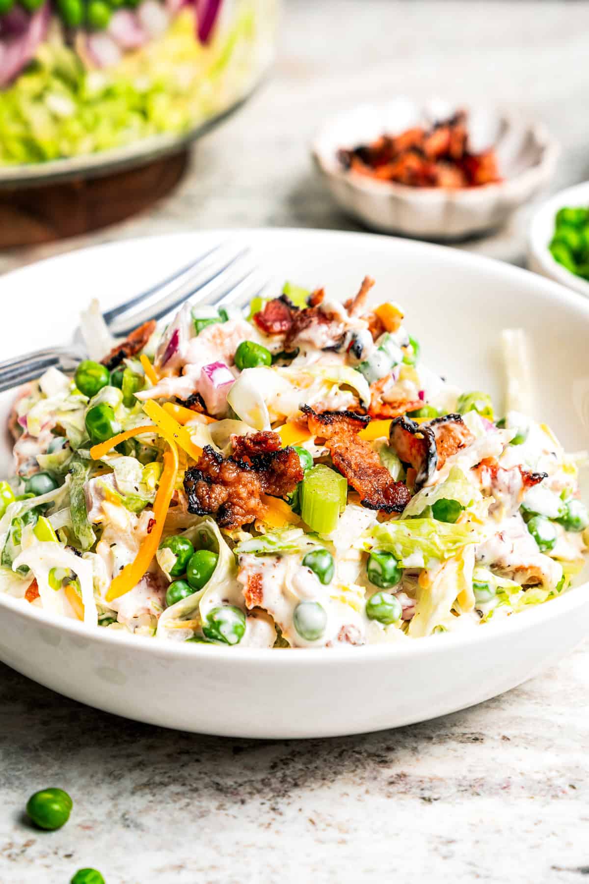 A serving of seven layer salad with creamy dressing in a bowl.