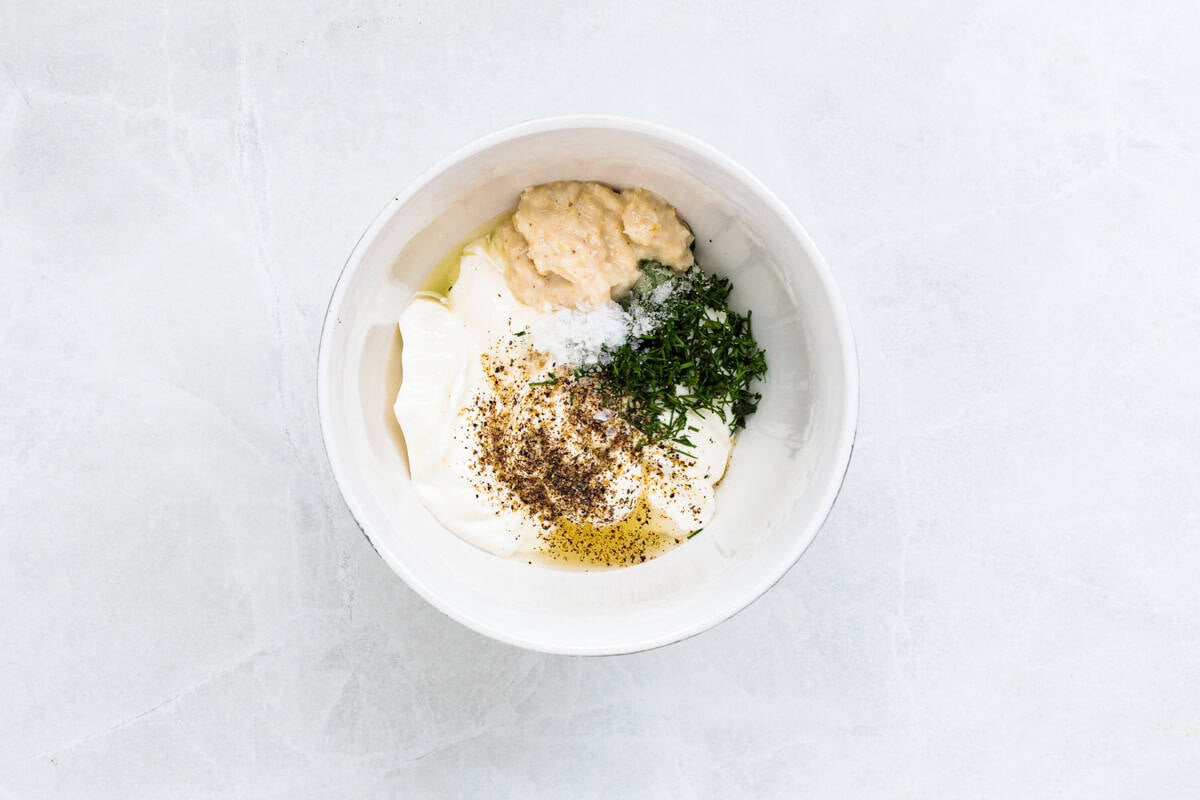 Baked steelhead trout with lemon, butter, garlic, and fresh dill. This easy steelhead trout recipe is tender, flaky, and ready in 30 minutes. A bowl of ingredients to make horseradish sour cream dill sauce.