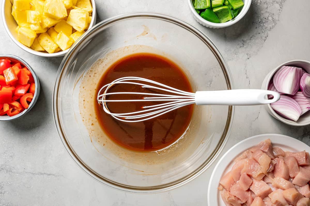Chicken marinade in a bowl with a whisk.