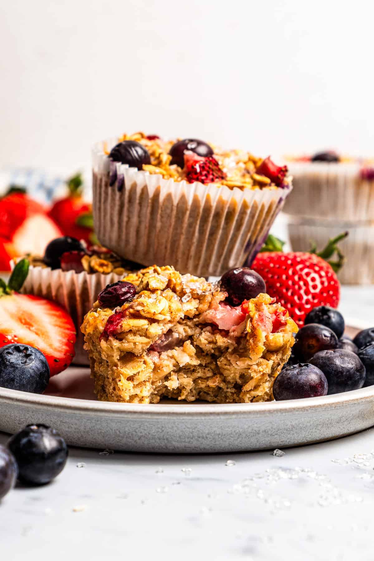 Make this cream cheese stuffed French toast with thick slices of custard-dipped brioche filled with sweet mascarpone and fresh lemon zest. Baked oatmeal cups stacked on a plate surrounded by fresh strawberries and blueberries.