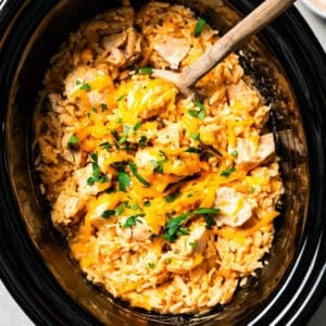 Overhead view of cheesy cream of mushroom chicken and rice in the slow cooker.